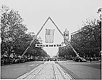 Photograph of a banner welcoming the Shah of Iran to Washington, during a parade in the Shah's honor, with a view of the Capitol in the background., 11/16/1949  - ARC Identifier: 200146.